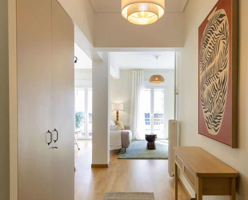 Entrance hallway leading into bright living area in furnished long stay apartment in Ano Petralona, Athens