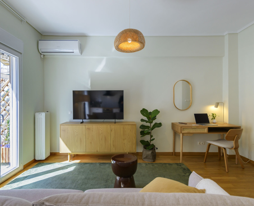 Bright living room with dedicated workspace, smart TV and air conditioning in furnished long stay apartment in Ano Petralona, Athens