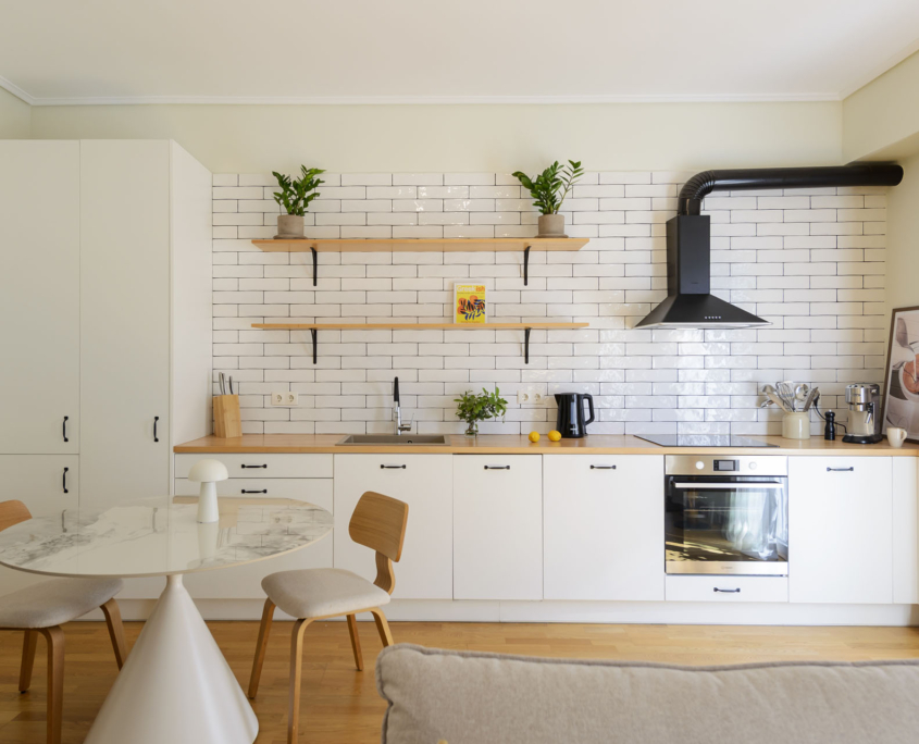 Fully equipped open kitchen with dishwasher, fridge freezer and dining area in furnished long stay apartment in Ano Petralona, Athens