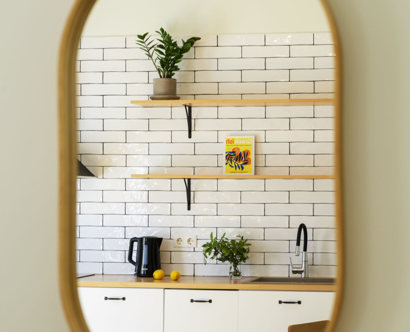 Interior mirror detail with view into open kitchen in furnished long stay apartment in Ano Petralona, Athens