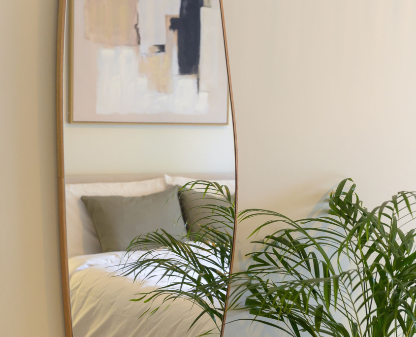 Full-length bedroom mirror reflecting double bed in furnished long stay apartment in Ano Petralona, Athens
