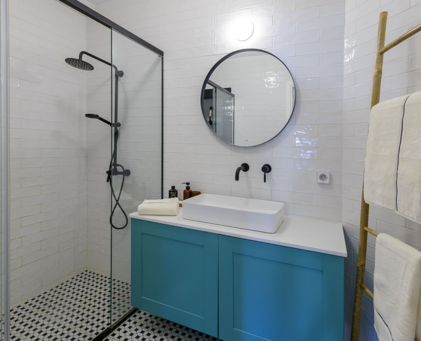 Modern bathroom with walk-in rain shower, vanity storage and fresh towels in furnished long stay apartment in Ano Petralona, Athens